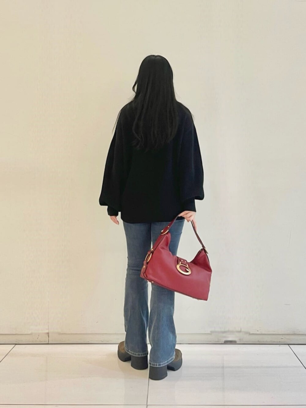 ブルー系のデニムパンツ、ブラック系のタンクトップ、ブラック系のカーディガン/ボレロを着用したレディースの秋コーディネートの2枚目の写真