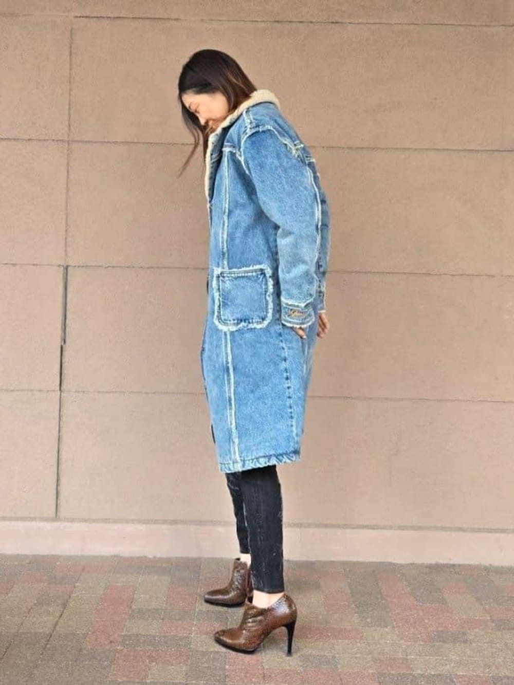 ブラック系のデニムパンツ、ブラウン系のニット/セーター、ブラック系のショルダーバッグを着用したレディースの春コーディネートの4枚目の写真