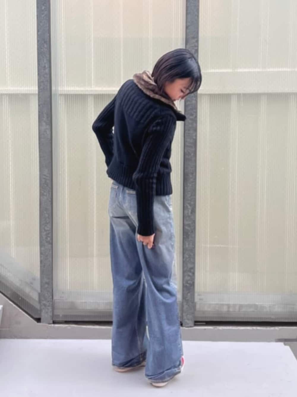 ブルー系のデニムパンツ、ブラック系のカーディガン/ボレロを着用したレディースの冬コーディネートの3枚目の写真