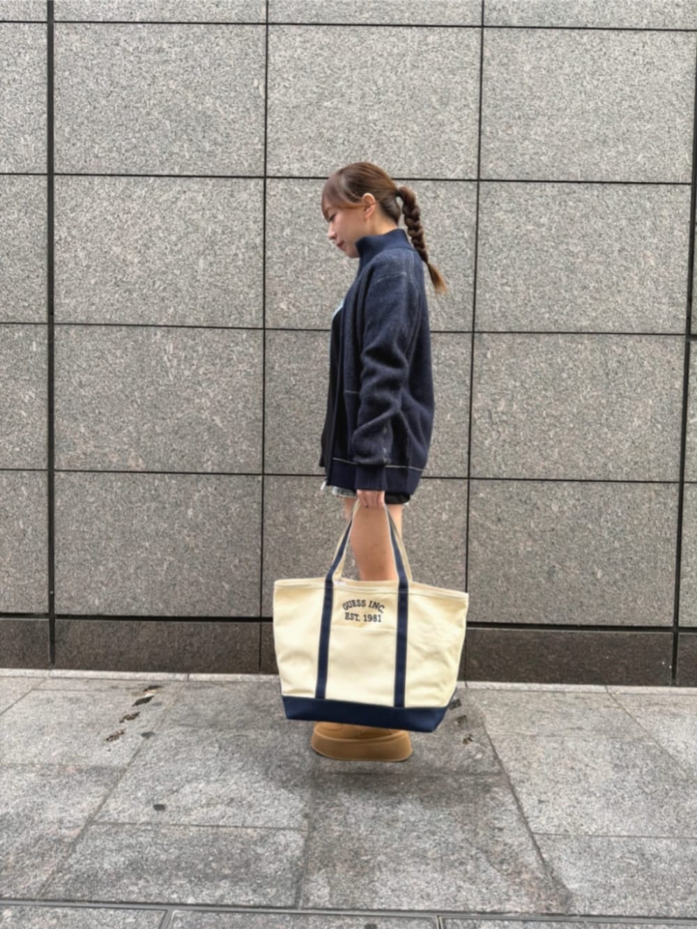 ブルー系のデニムパンツ、ブラック系のTシャツ/カットソー、ブルー系のトートバッグを着用したレディースの冬コーディネートの3枚目の写真