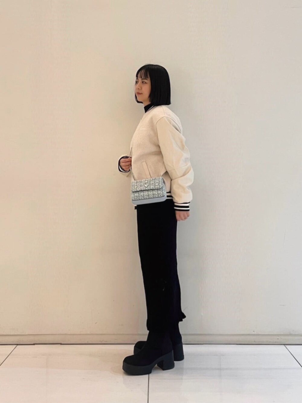 ブラック系のワンピース、その他のショルダーバッグ、ホワイト系のスタジャンを着用したレディースの冬コーディネートの3枚目の写真