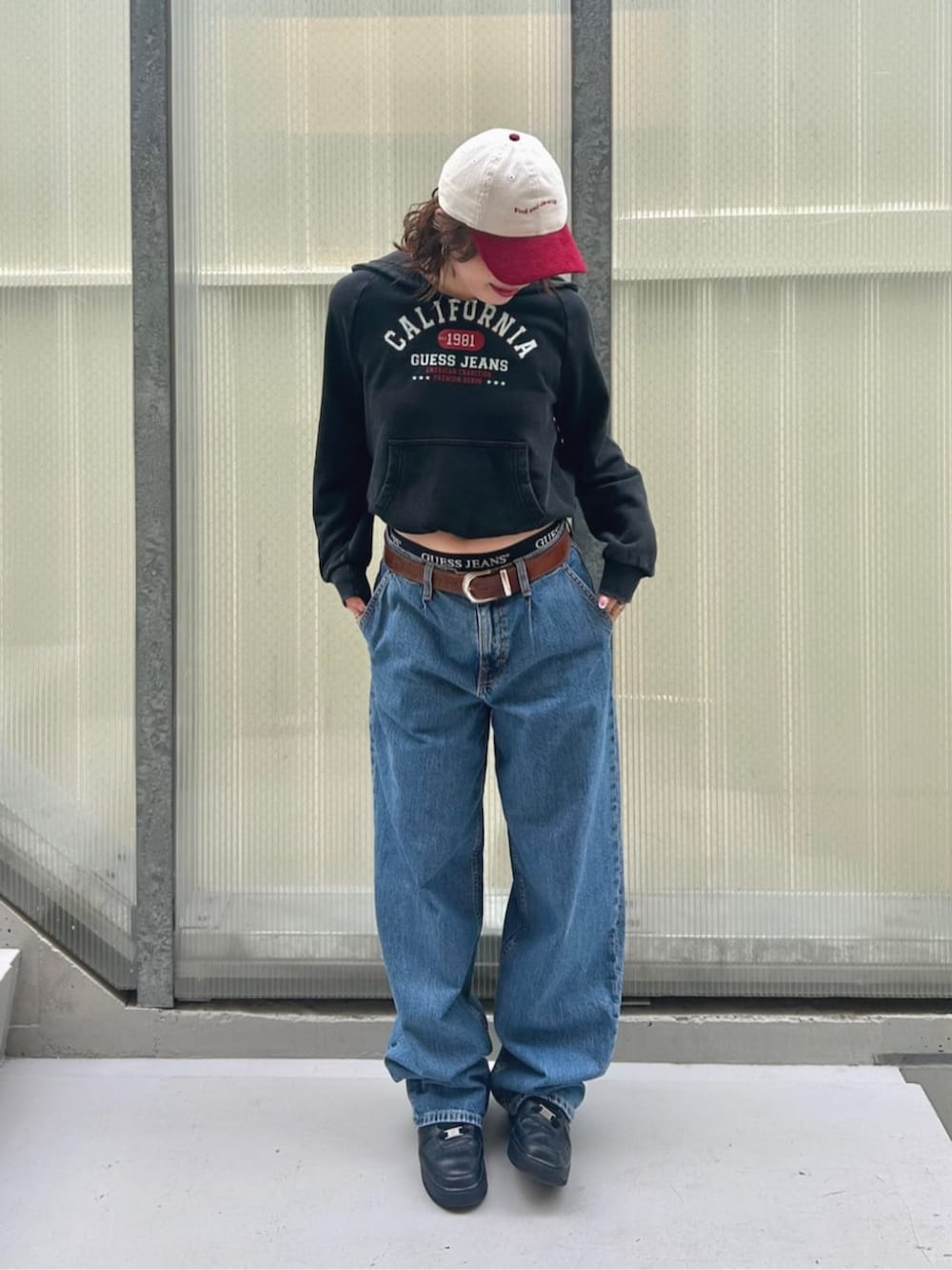 ブルー系のデニムパンツ、ブラック系のパーカー、ブラック系のボクサーパンツを着用したレディースの秋コーディネートの4枚目の写真