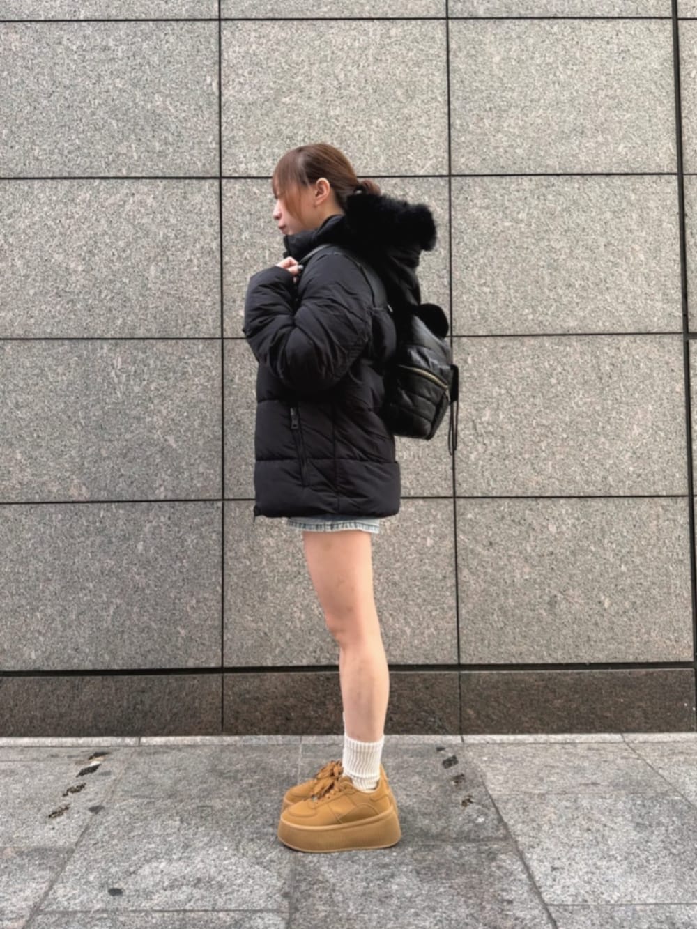 ブルー系のデニムパンツ、ブルー系のスウェット、ブラック系のその他アウターを着用したレディースの冬コーディネートの3枚目の写真