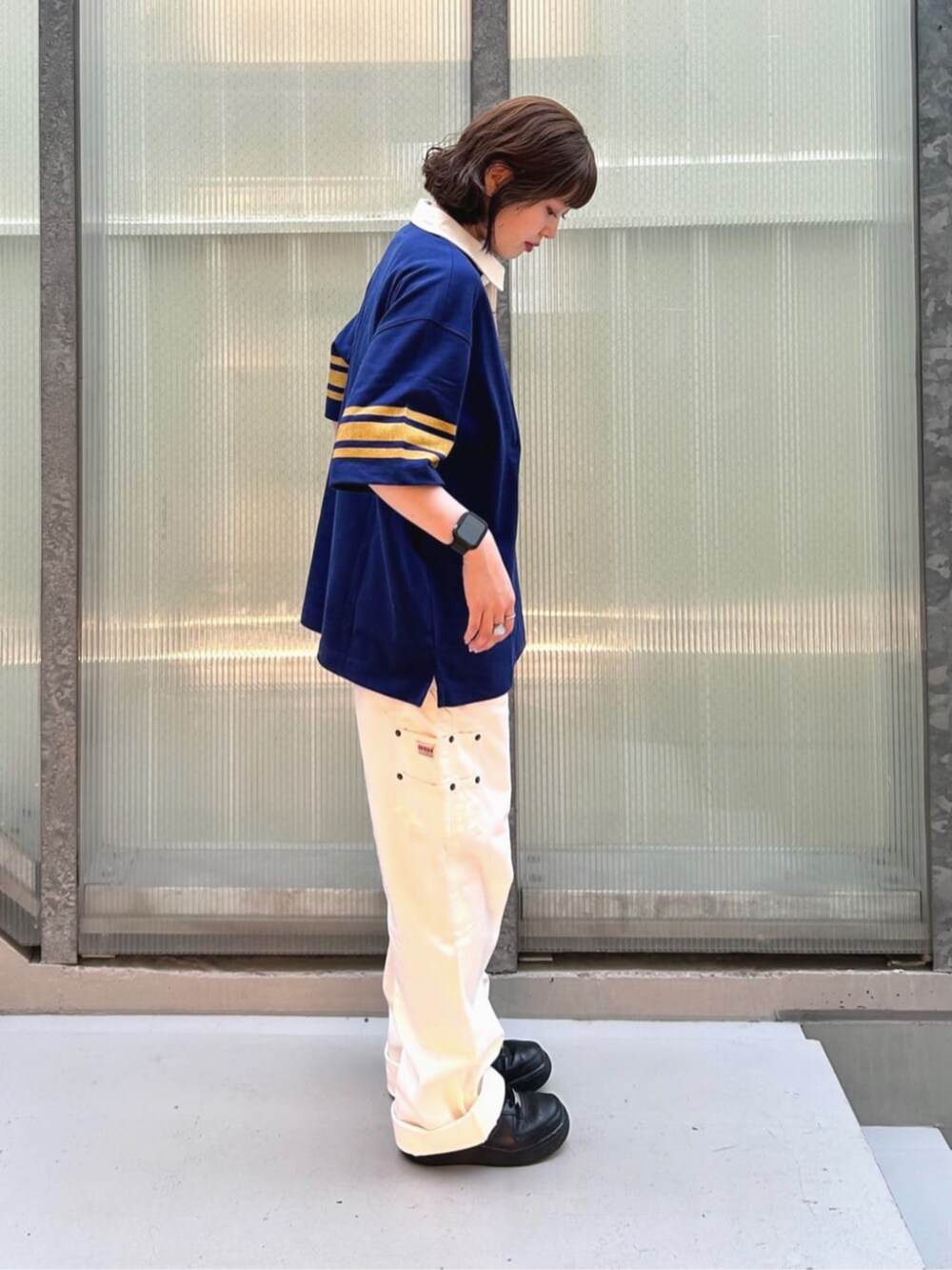 ブルー系のポロシャツ、ホワイト系のカーゴパンツを着用したレディースの秋コーディネートの3枚目の写真