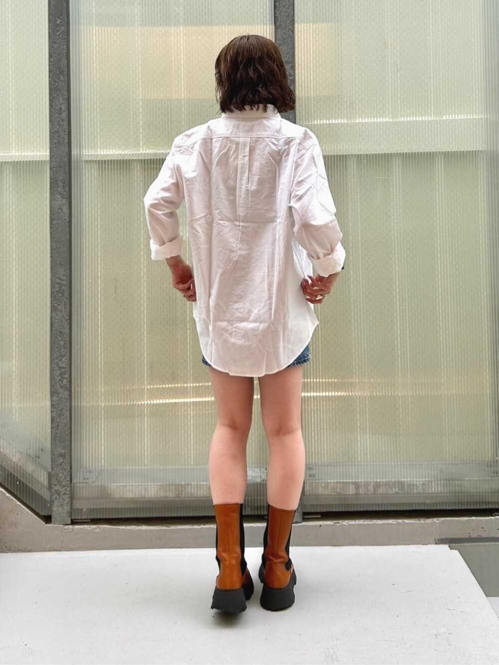 ホワイト系のシャツ/ブラウス、ブルー系のデニムスカート、グレー系のタンクトップを着用したレディースの秋コーディネートの2枚目の写真