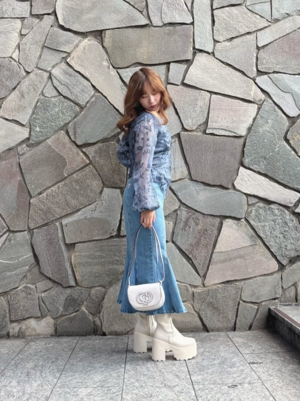 ホワイト系のショルダーバッグ、ブルー系のシャツ/ブラウス、ブルー系のデニムスカートを着用したレディースの秋コーディネートの3枚目の写真