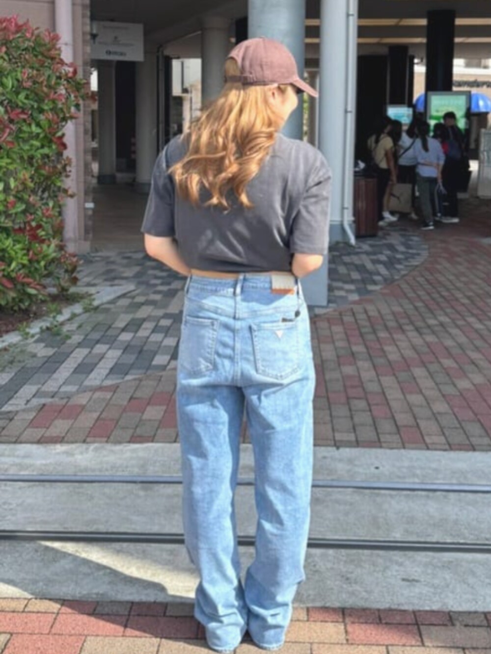 ブルー系のデニムパンツ、グレー系のTシャツ/カットソーを着用したレディースの夏コーディネートの2枚目の写真