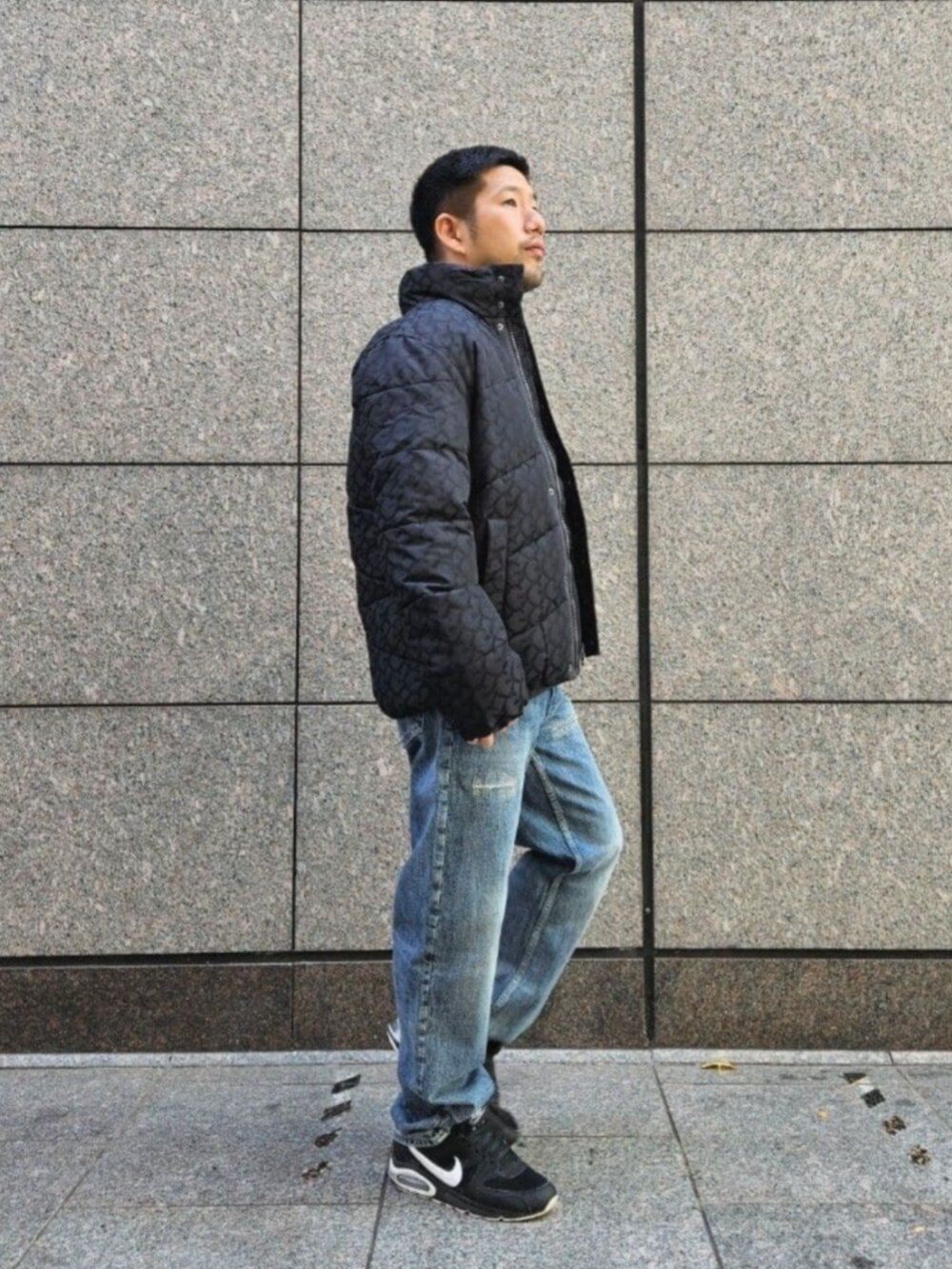 ブルー系のデニムパンツ、ブラック系のニット/セーター、ブラック系のその他アウターを着用したメンズの冬コーディネートの3枚目の写真
