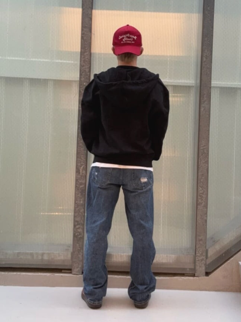 ブルー系のデニムパンツ、ブラック系のパーカー、ホワイト系のTシャツ/カットソーを着用したメンズの冬コーディネートの2枚目の写真