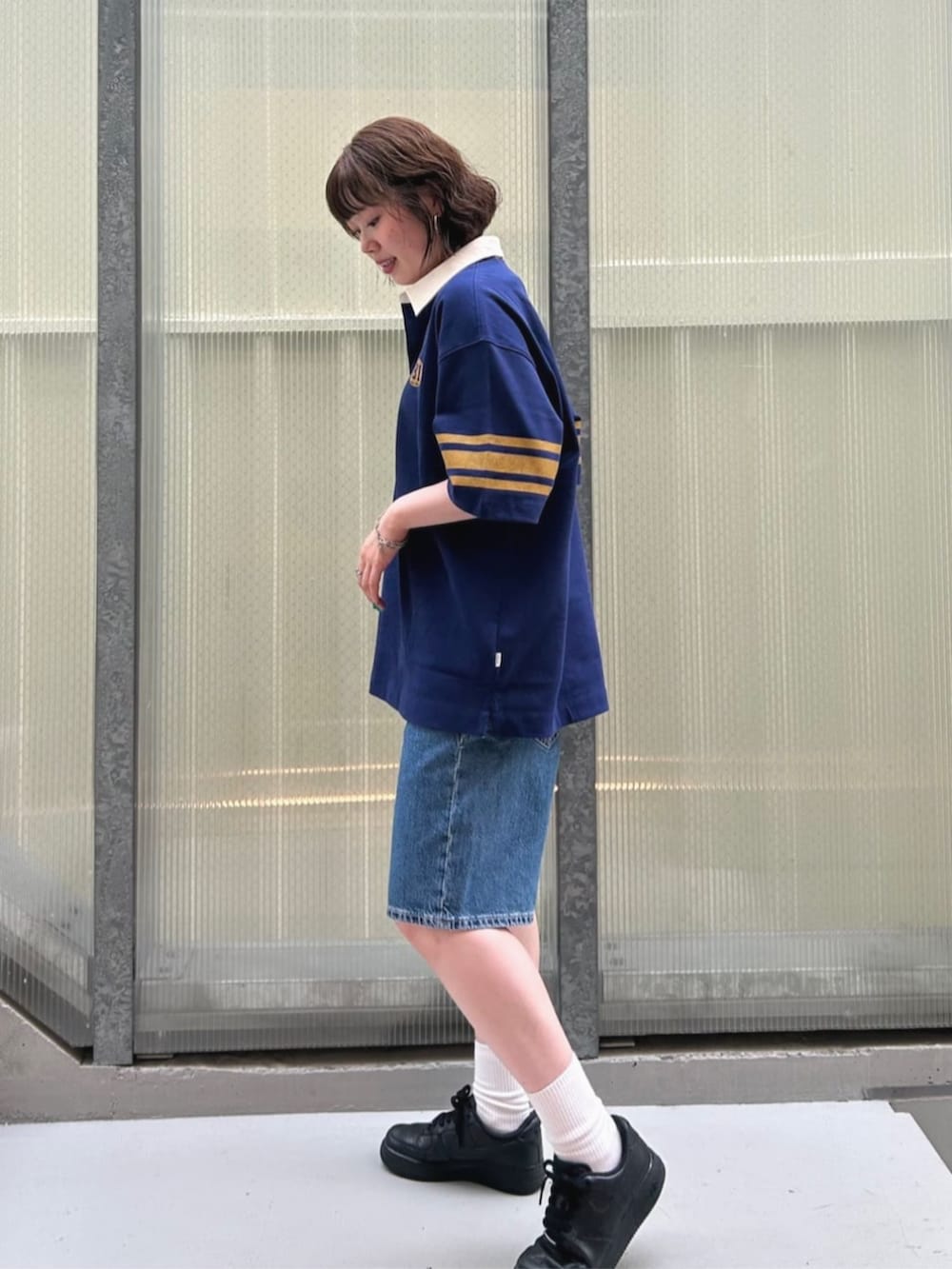 ブルー系のポロシャツ、ブルー系のデニムパンツを着用したレディースの夏コーディネートの3枚目の写真