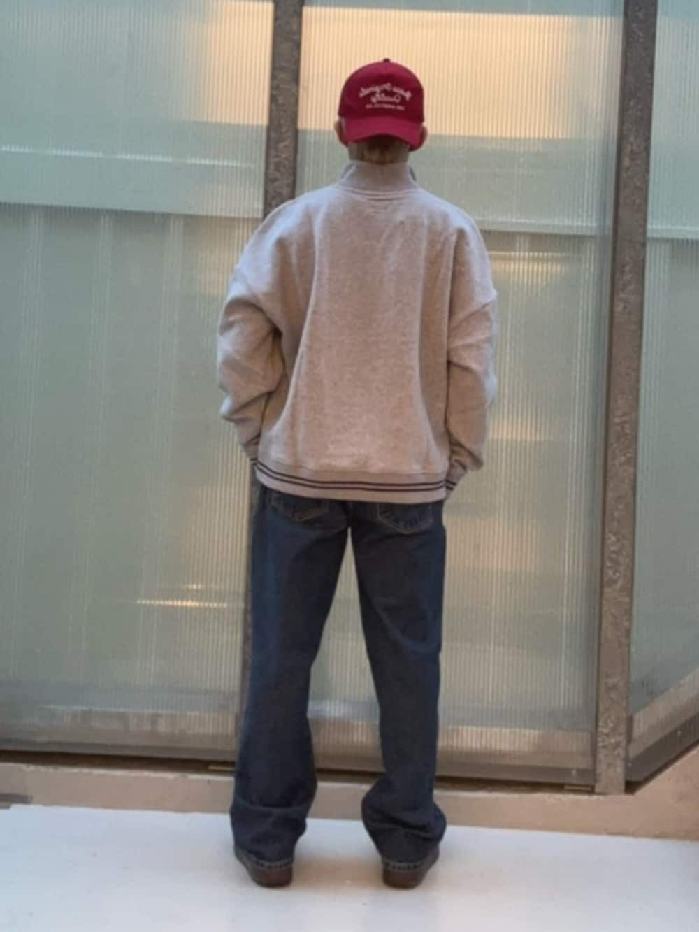 グレー系のスウェット、ブルー系のデニムパンツを着用したメンズの冬コーディネートの2枚目の写真