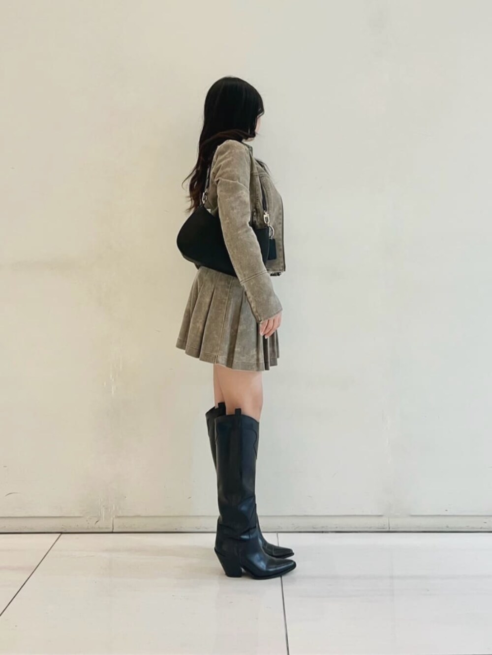 ブラック系のショルダーバッグ、ホワイト系のニット/セーター、ベージュ系のスカートを着用したレディースの秋コーディネートの3枚目の写真