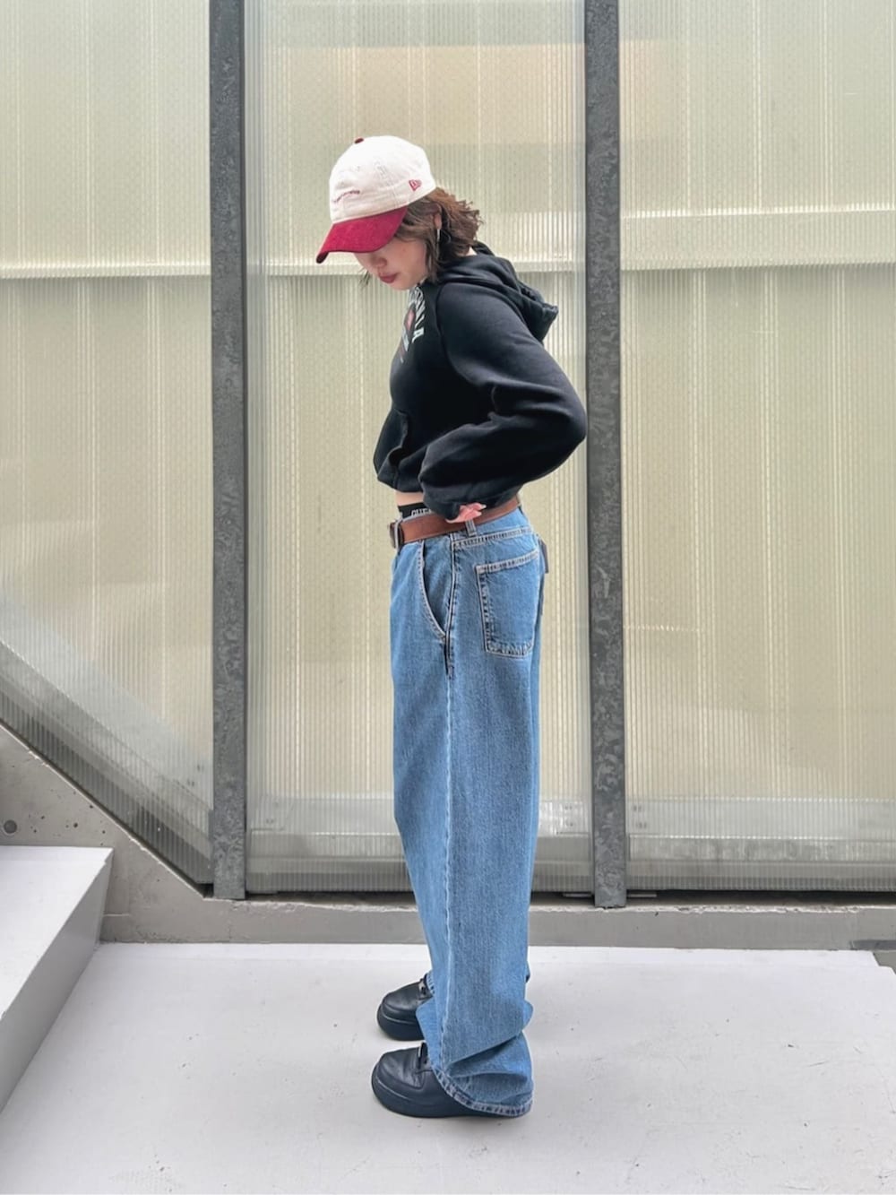 ブルー系のデニムパンツ、ブラック系のパーカー、ブラック系のボクサーパンツを着用したレディースの秋コーディネートの3枚目の写真