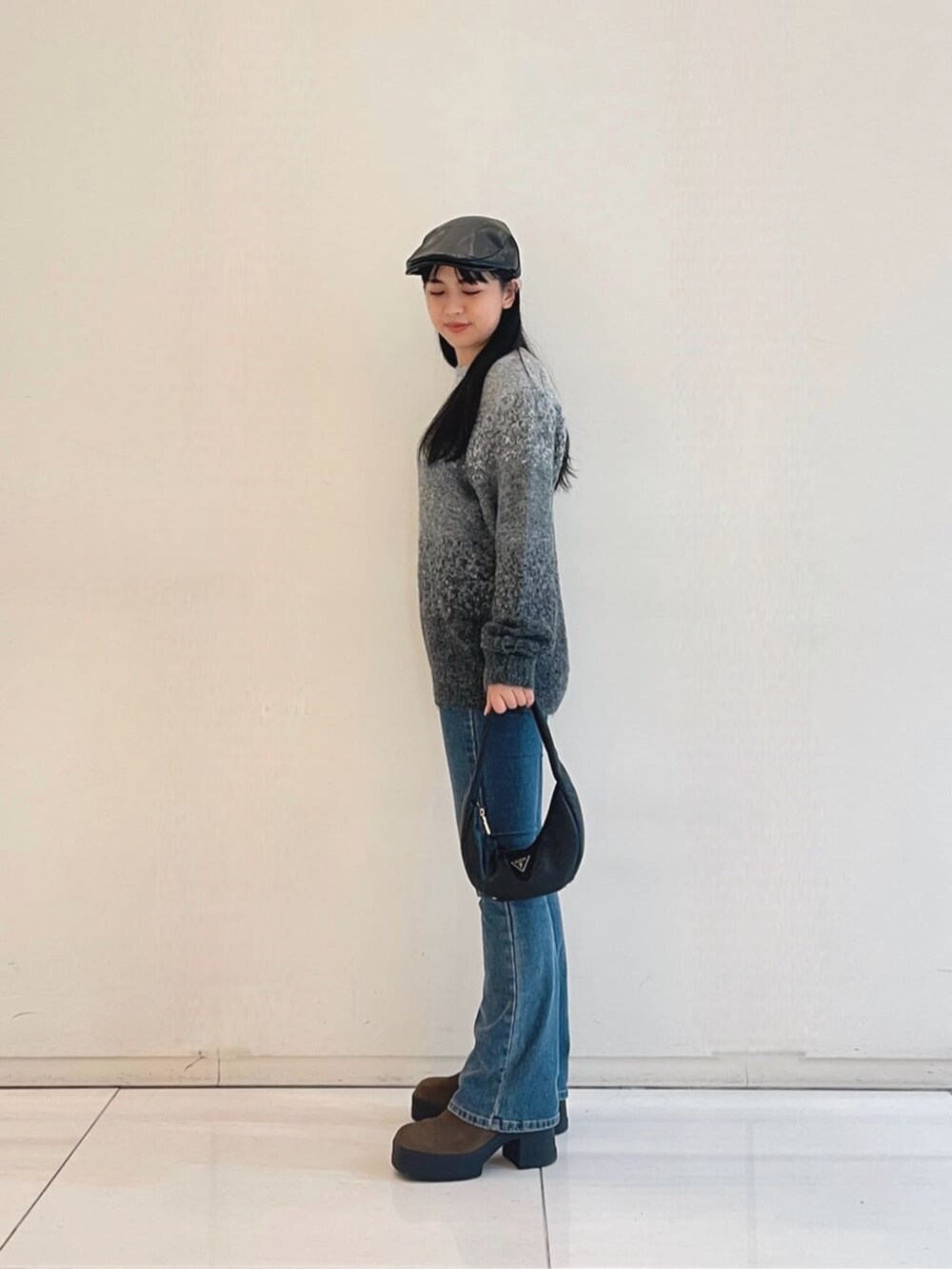 ブルー系のデニムパンツ、グレー系のニット/セーター、ブラック系のショルダーバッグを着用したレディースの秋コーディネートの3枚目の写真