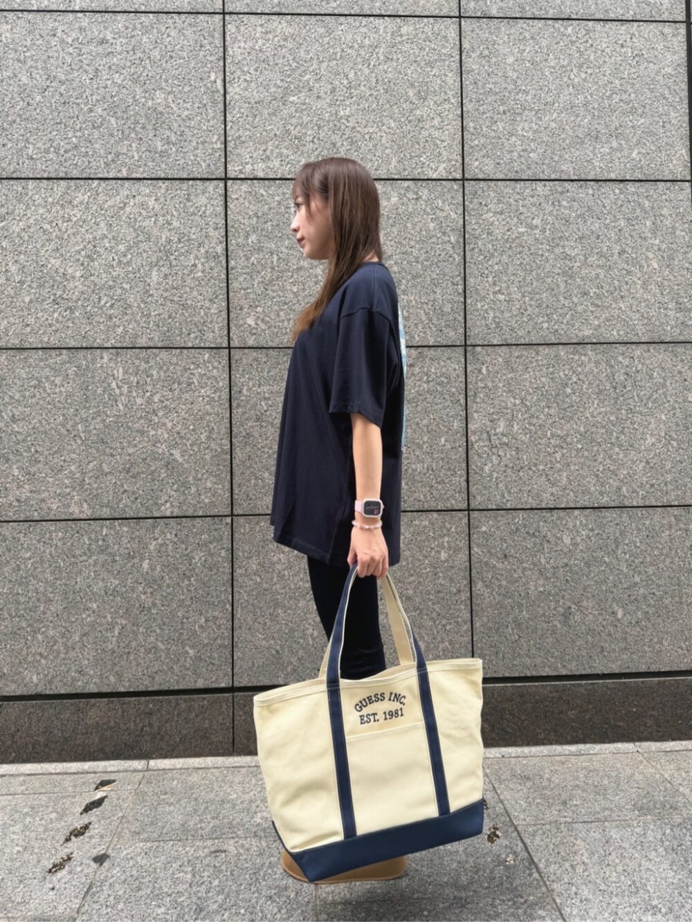 ブルー系のデニムパンツ、ブルー系のトートバッグ、ブルー系のTシャツ/カットソーを着用したレディースの秋コーディネートの3枚目の写真