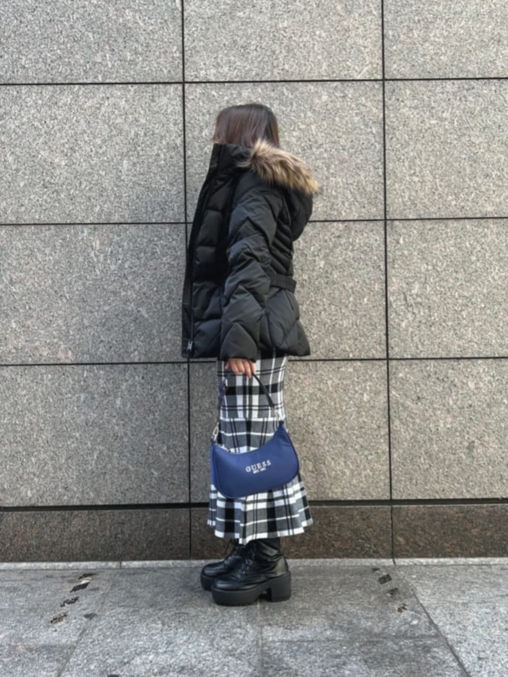 ブラック系のワンピース、ブルー系のショルダーバッグ、ブラック系のダウンジャケット/コートを着用したレディースの冬コーディネートの3枚目の写真