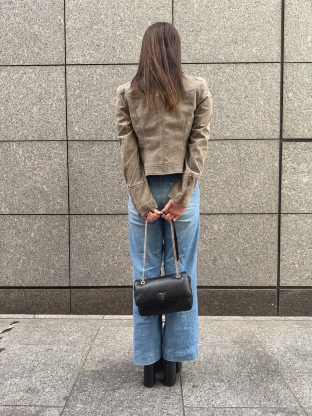 ブルー系のデニムパンツ、ホワイト系のニット/セーター、ベージュ系のノーカラージャケットを着用したレディースの秋コーディネートの2枚目の写真