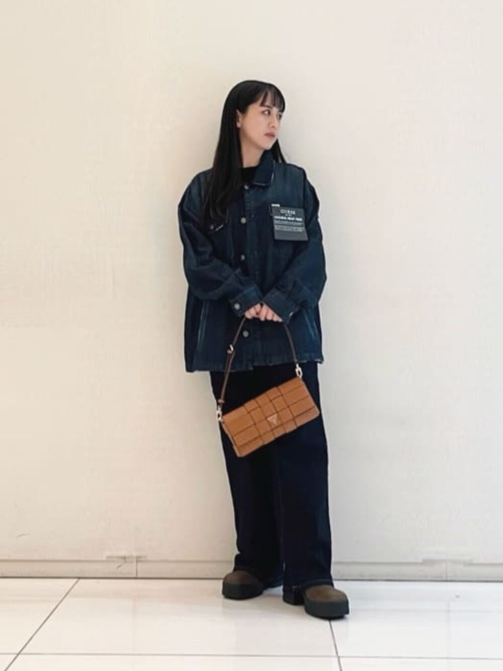 ブルー系のシャツ/ブラウス、イエロー系のショルダーバッグ、ブラック系のニット/セーターを着用したレディースの秋コーディネートの4枚目の写真