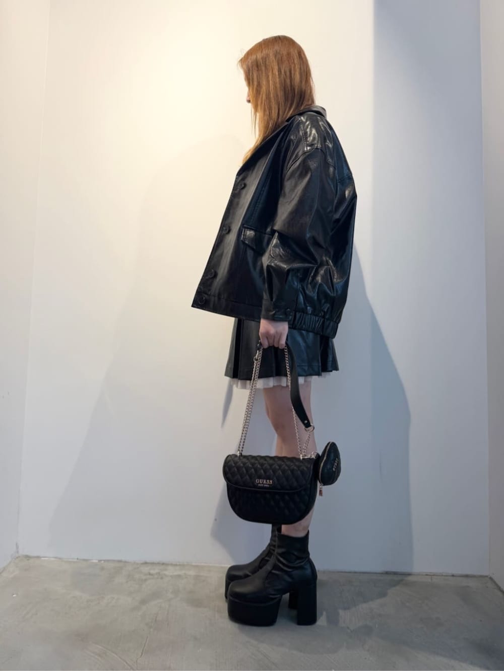 ブラック系のショルダーバッグ、ブラック系のカバーオール、ブラック系のワンピースを着用したレディースの春コーディネートの3枚目の写真