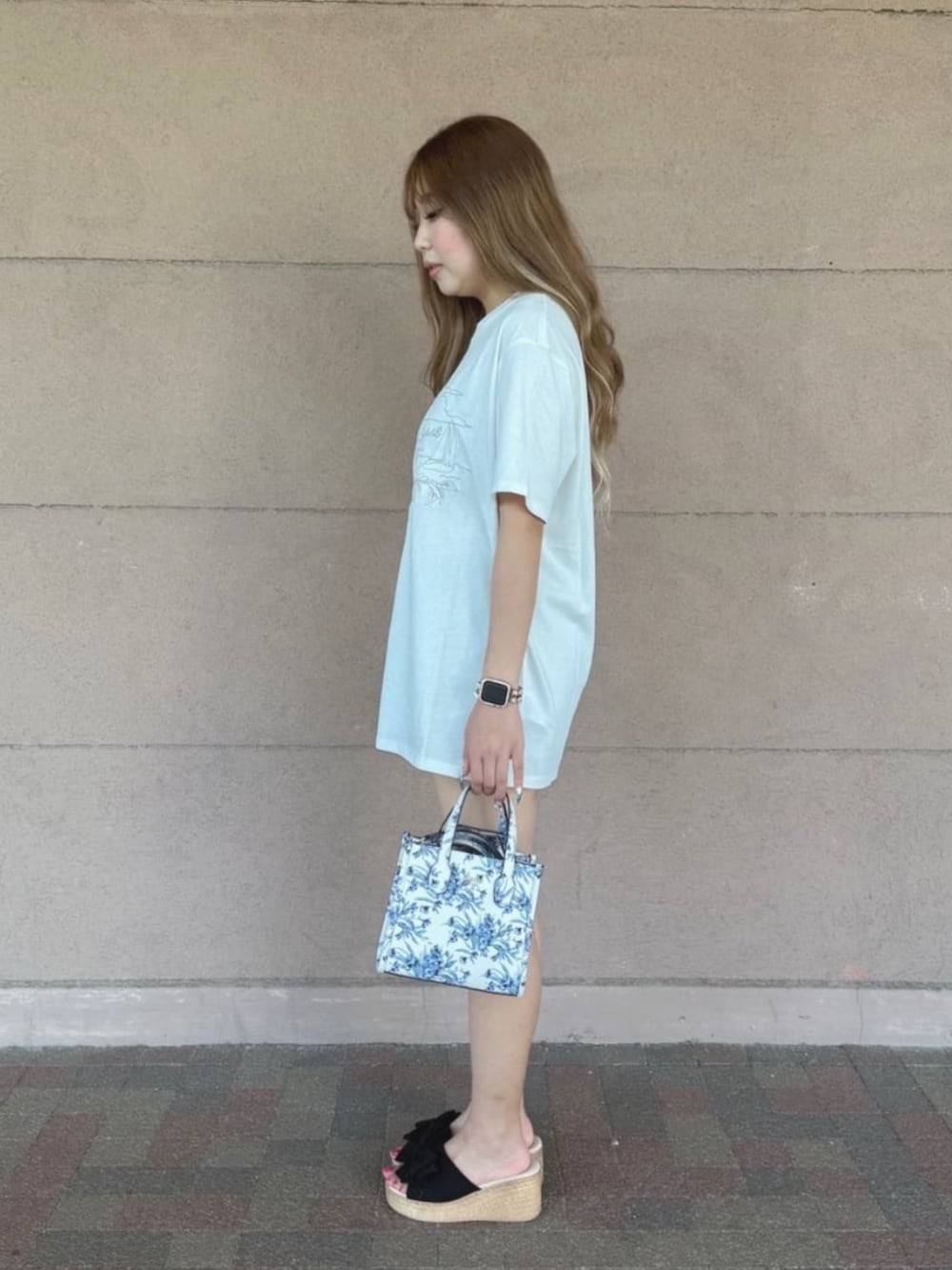 ホワイト系のショルダーバッグ、ブルー系のデニムパンツ、ホワイト系のTシャツ/カットソーを着用したレディースの夏コーディネートの3枚目の写真