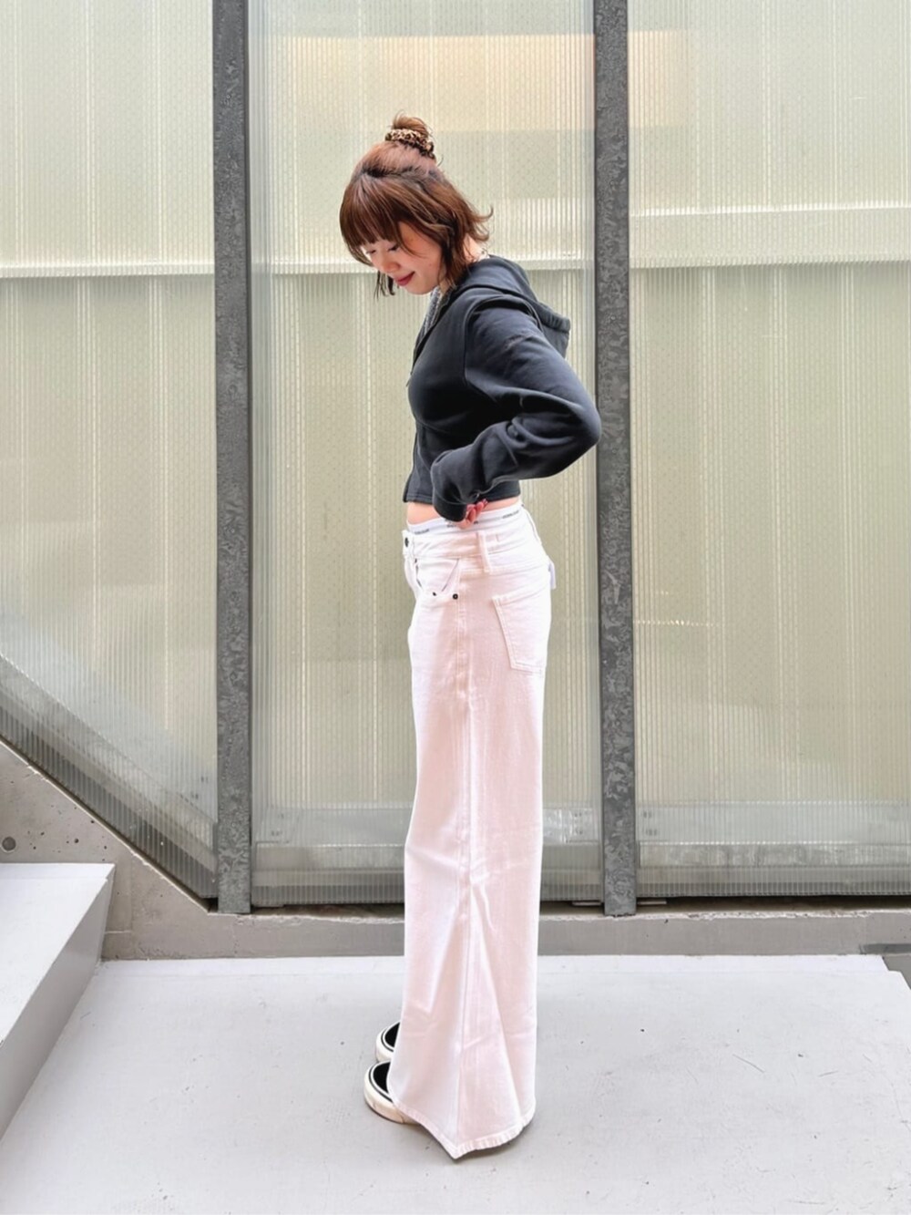 ホワイト系のデニムパンツ、ブラック系のパーカー、グレー系のショーツを着用したレディースの秋コーディネートの3枚目の写真