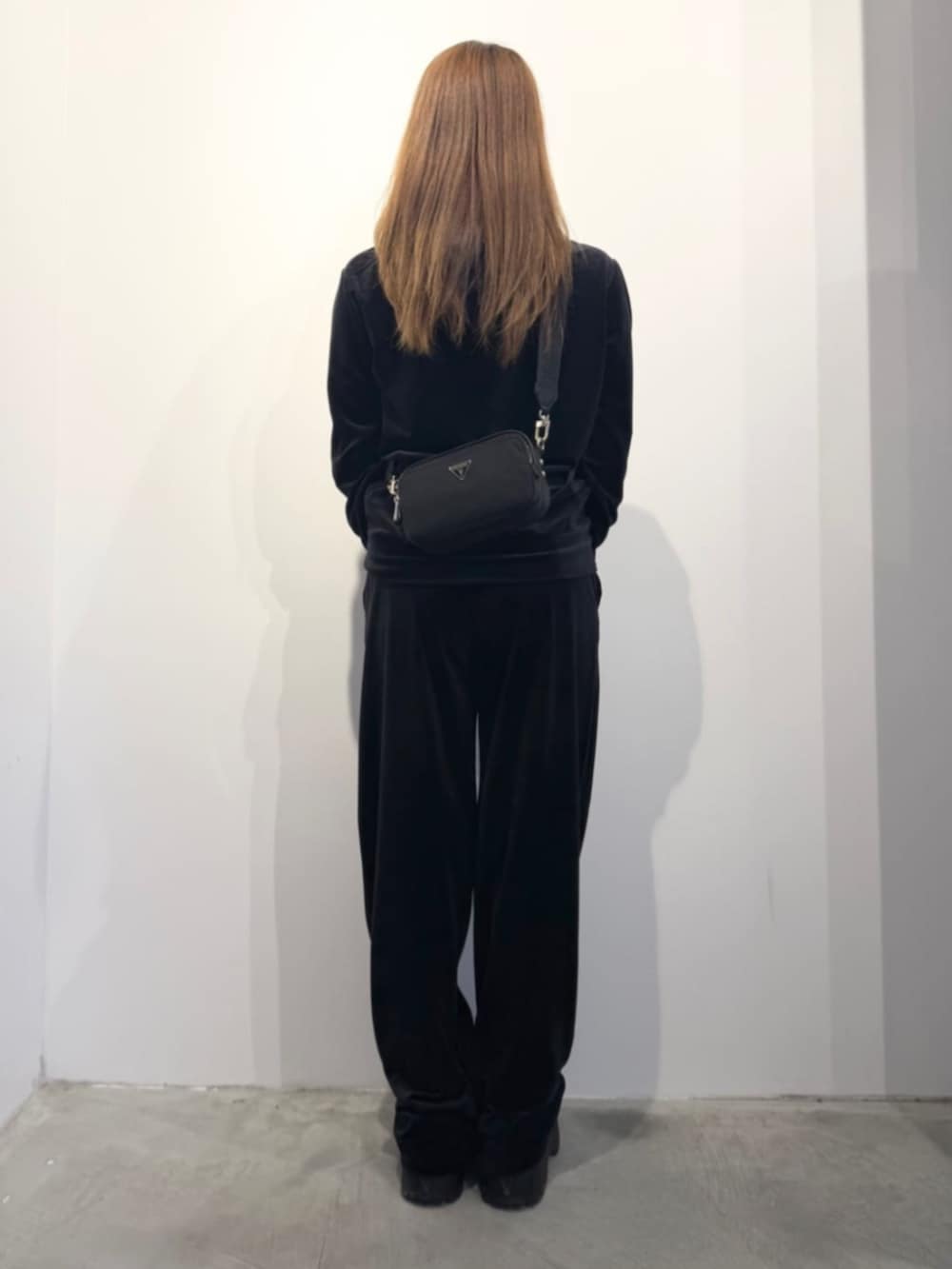 ブラック系のショルダーバッグ、ブラック系のパーカー、ブラック系のスウェットパンツを着用したレディースの春コーディネートの2枚目の写真