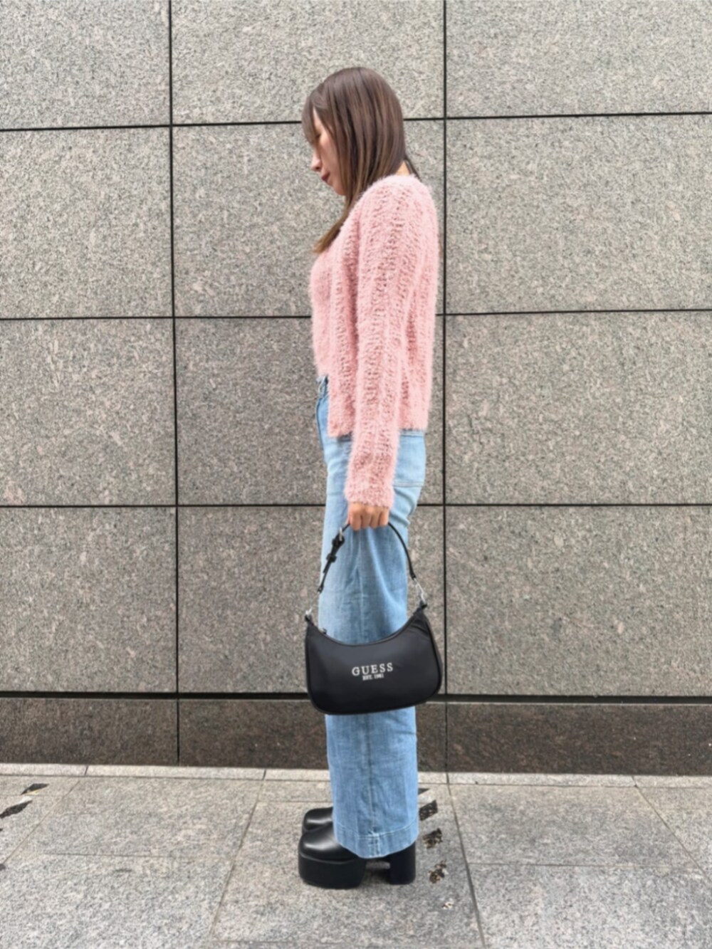 ブルー系のデニムパンツ、ブラック系のショルダーバッグ、ピンク系のキャミソールを着用したレディースの秋コーディネートの3枚目の写真