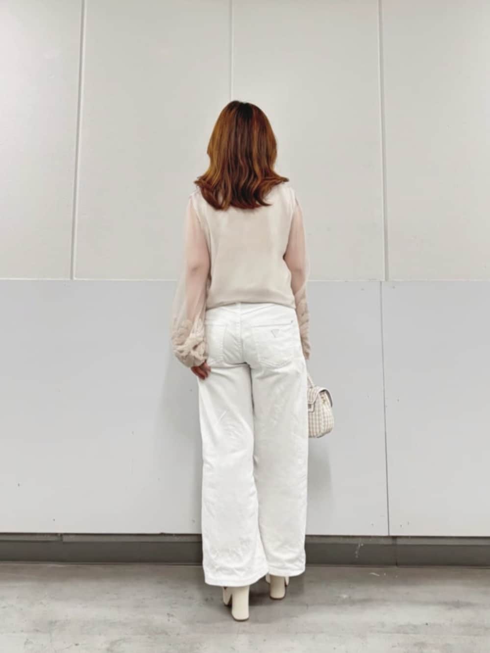 ホワイト系のデニムパンツ、ベージュ系のシャツ/ブラウス、ホワイト系のショルダーバッグを着用したレディースの秋コーディネートの2枚目の写真