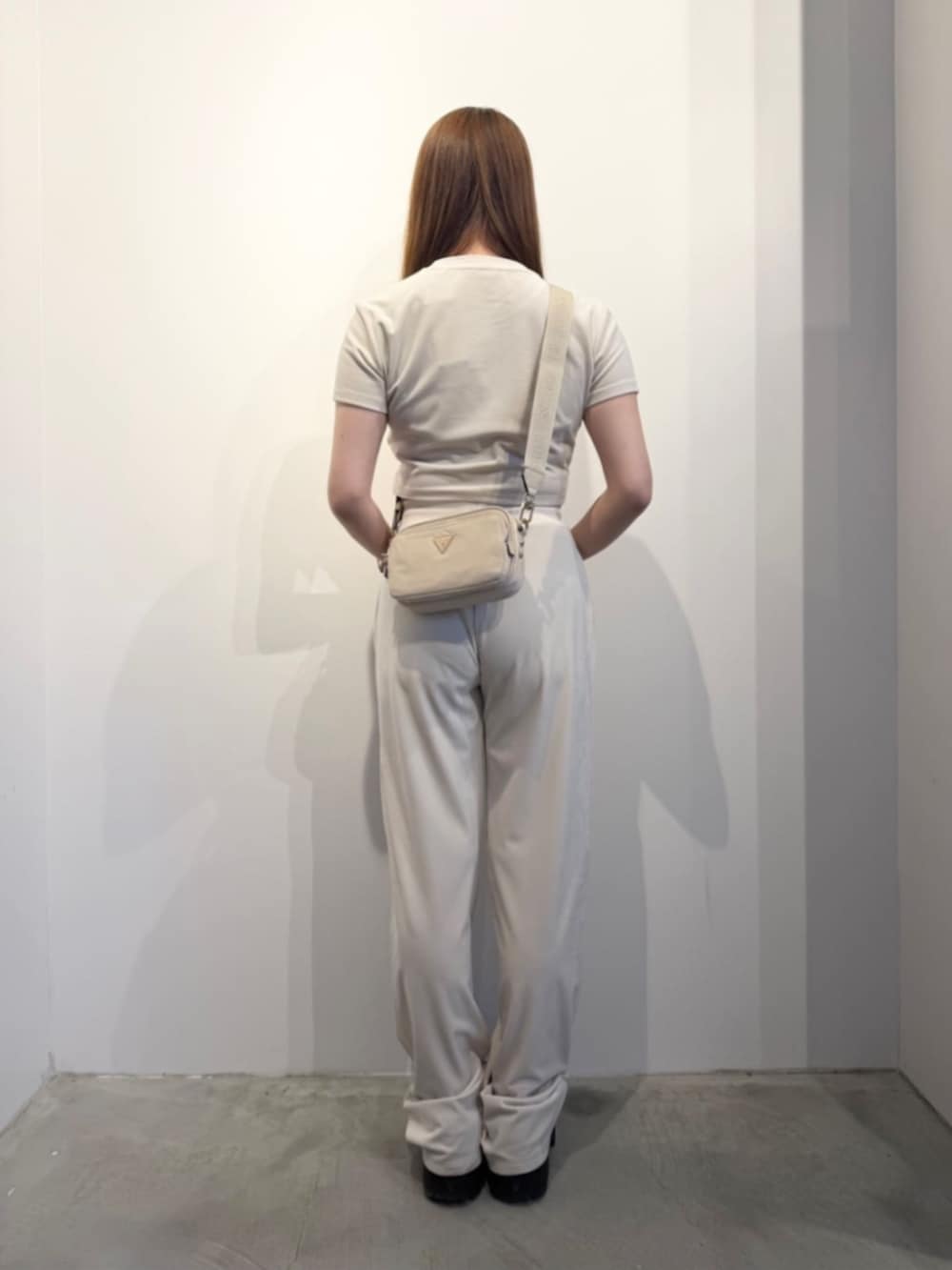 ベージュ系のショルダーバッグ、ホワイト系のTシャツ/カットソー、ホワイト系のスウェットパンツを着用したレディースの春コーディネートの2枚目の写真