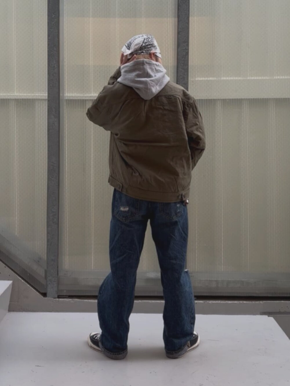 ブルー系のデニムパンツ、グレー系のパーカー、グリーン系のその他アウターを着用したレディースの秋コーディネートの2枚目の写真