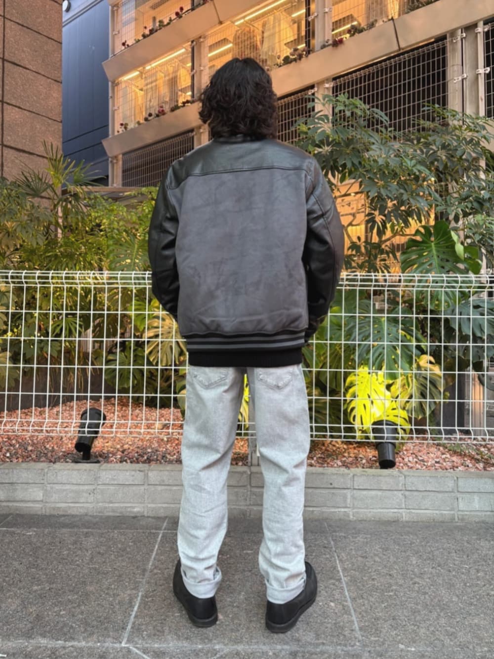 グレー系のデニムパンツ、グレー系のスタジャンを着用したメンズの秋コーディネートの2枚目の写真