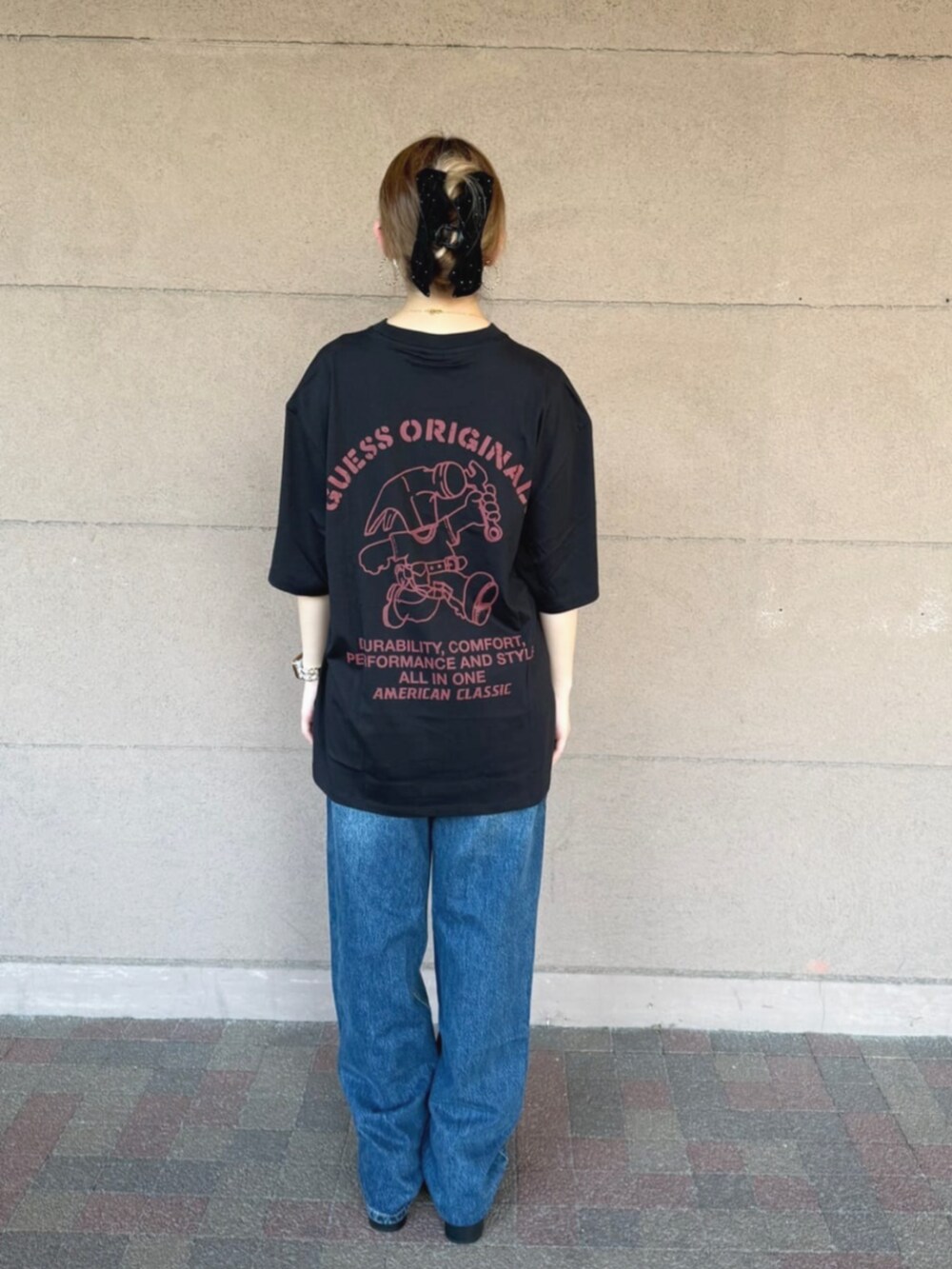 ブルー系のデニムパンツ、ブラック系のTシャツ/カットソーを着用したレディースの秋コーディネートの2枚目の写真