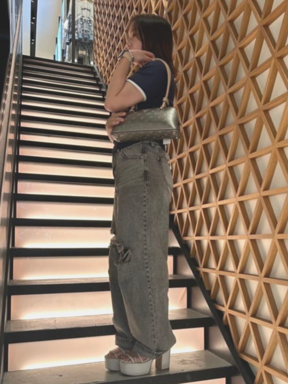 グレー系のショルダーバッグ、ブルー系のTシャツ/カットソー、グレー系のデニムパンツを着用したレディースの夏コーディネートの3枚目の写真