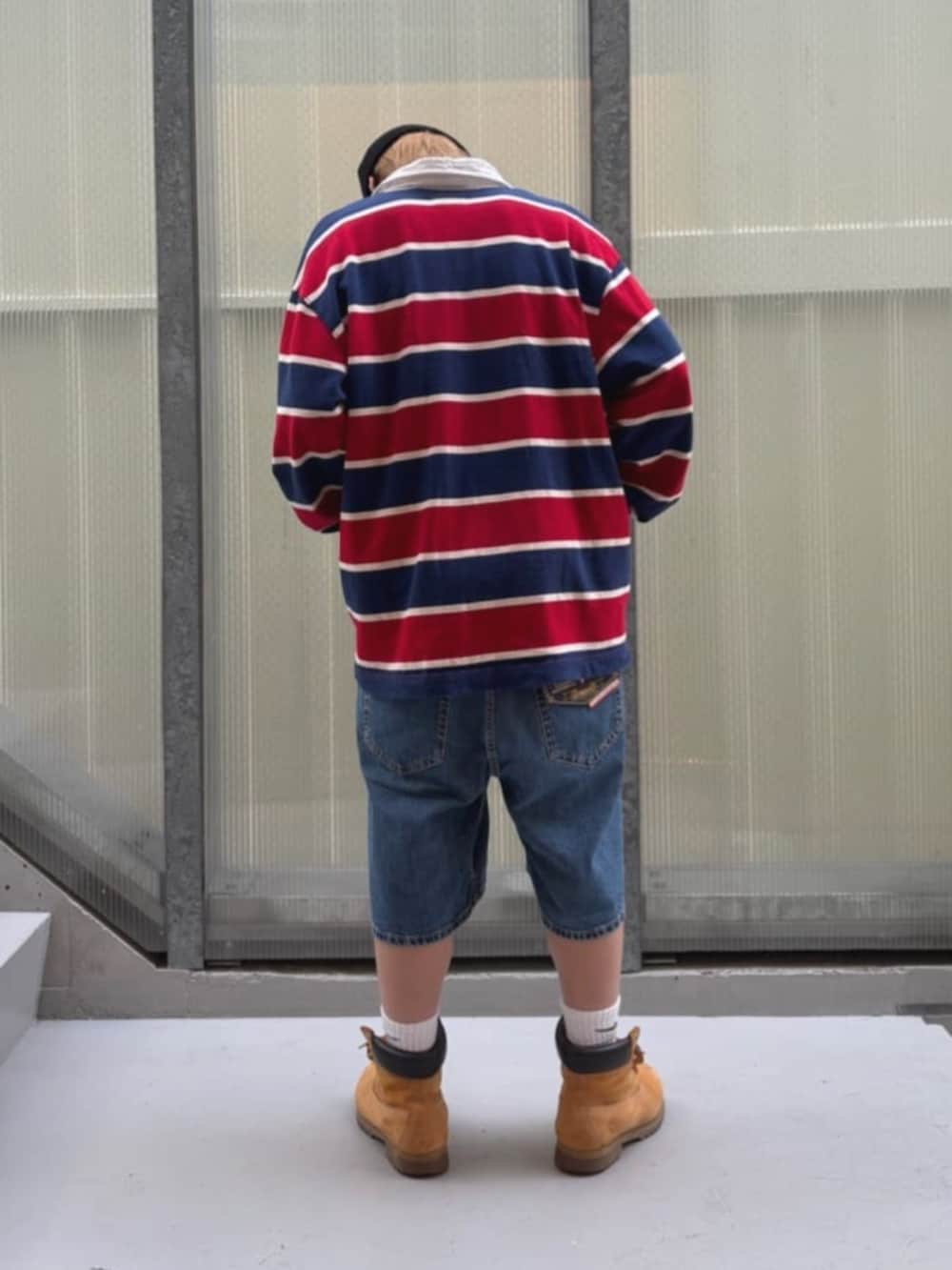 ホワイト系のTシャツ/カットソー、レッド系のポロシャツ、ブルー系のデニムパンツを着用したメンズの秋コーディネートの2枚目の写真