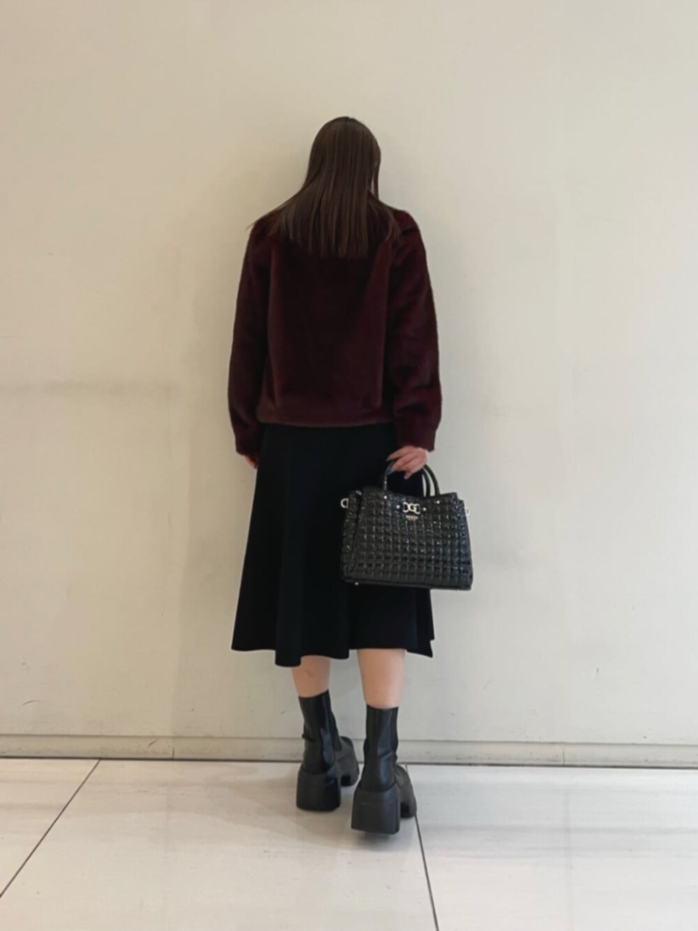 ブラック系のワンピース、レッド系のその他アウター、ブラック系のショルダーバッグを着用したレディースの冬コーディネートの2枚目の写真