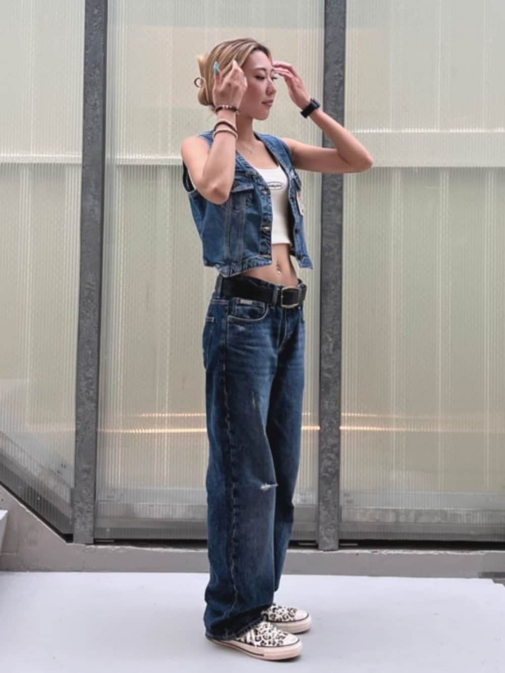 ブルー系のデニムパンツ、ブルー系のベストを着用したレディースの夏コーディネートの4枚目の写真