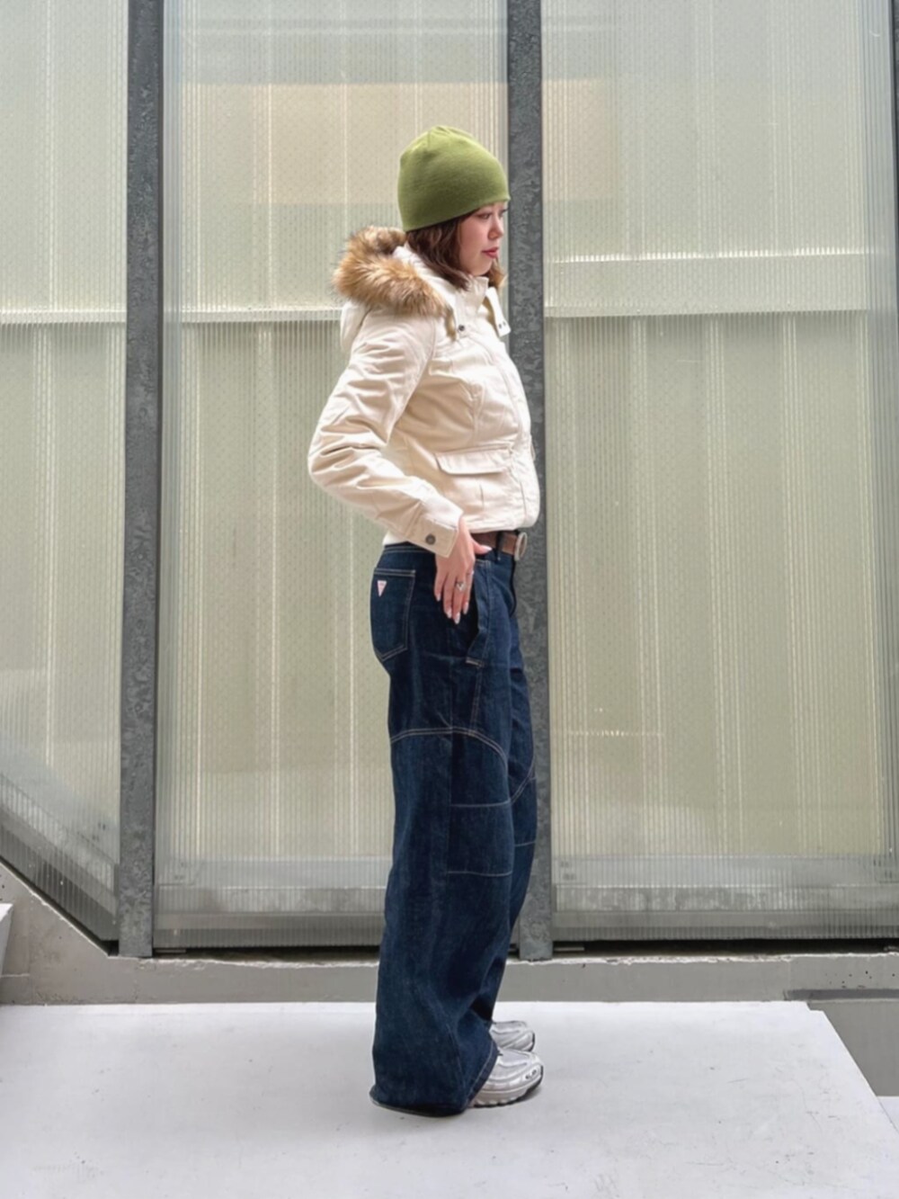 ブルー系のデニムパンツ、ブラック系のブルゾン、ブラック系のボクサーパンツを着用したレディースの冬コーディネートの3枚目の写真