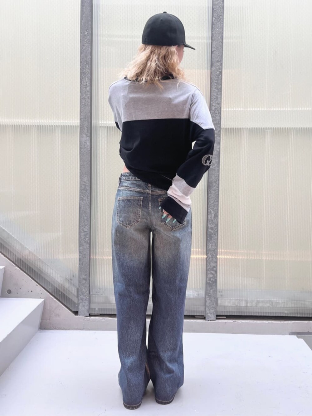 ブラック系のスウェット、ブルー系のデニムパンツを着用したレディースの夏コーディネートの2枚目の写真