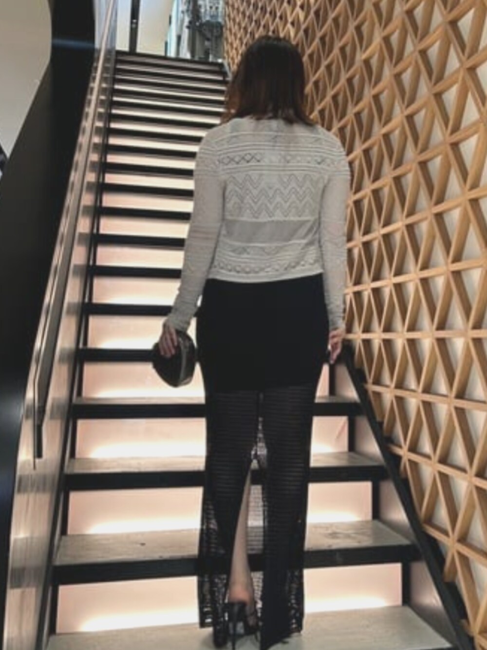 グレー系のショルダーバッグ、ブラック系のワンピース、ホワイト系のカーディガン/ボレロを着用したレディースの夏コーディネートの2枚目の写真