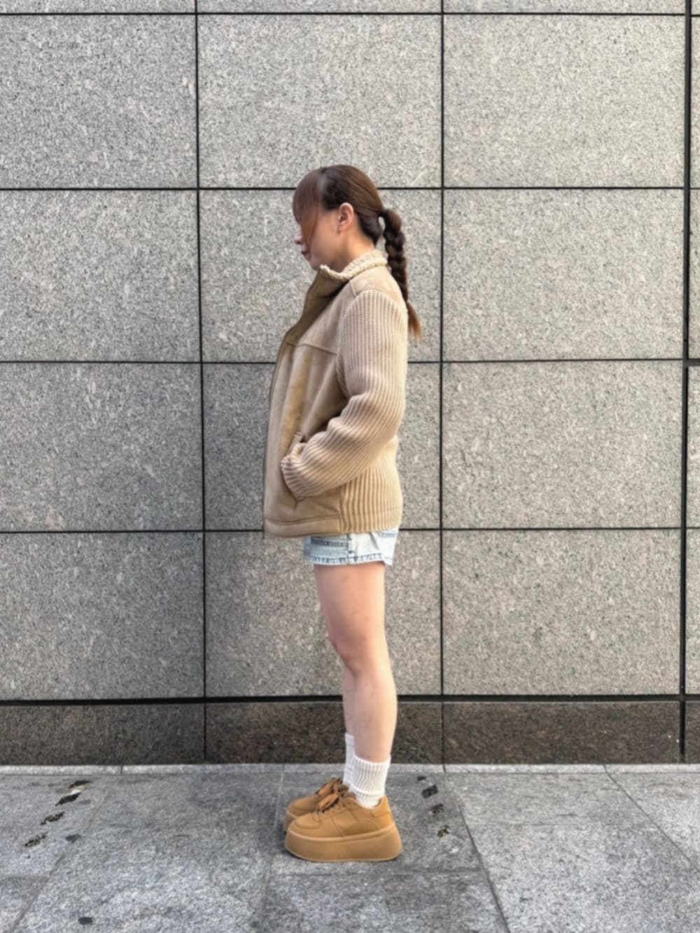 ブルー系のデニムパンツ、ブラック系のニット/セーター、ベージュ系のブルゾンを着用したレディースの冬コーディネートの3枚目の写真