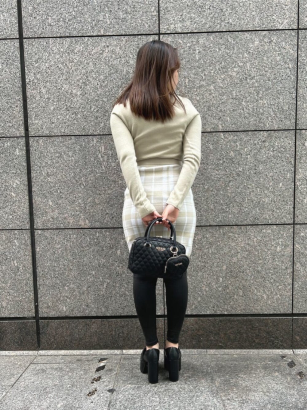 ホワイト系のワンピース、ブラック系のハンドバッグを着用したレディースの冬コーディネートの2枚目の写真