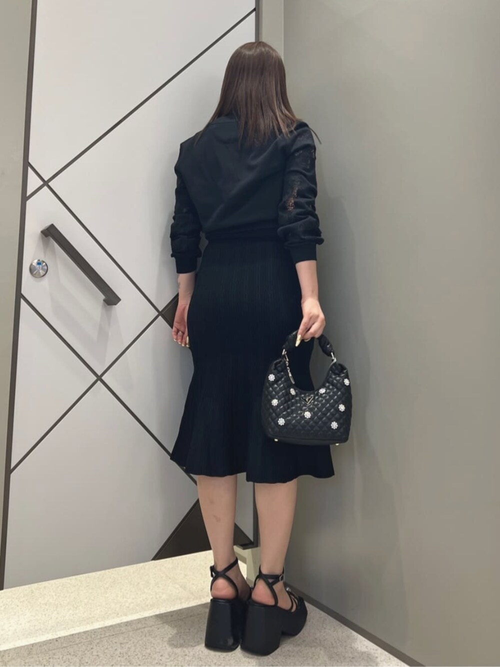 ブラック系のワンピース、ブラック系のショルダーバッグを着用したレディースの夏コーディネートの2枚目の写真