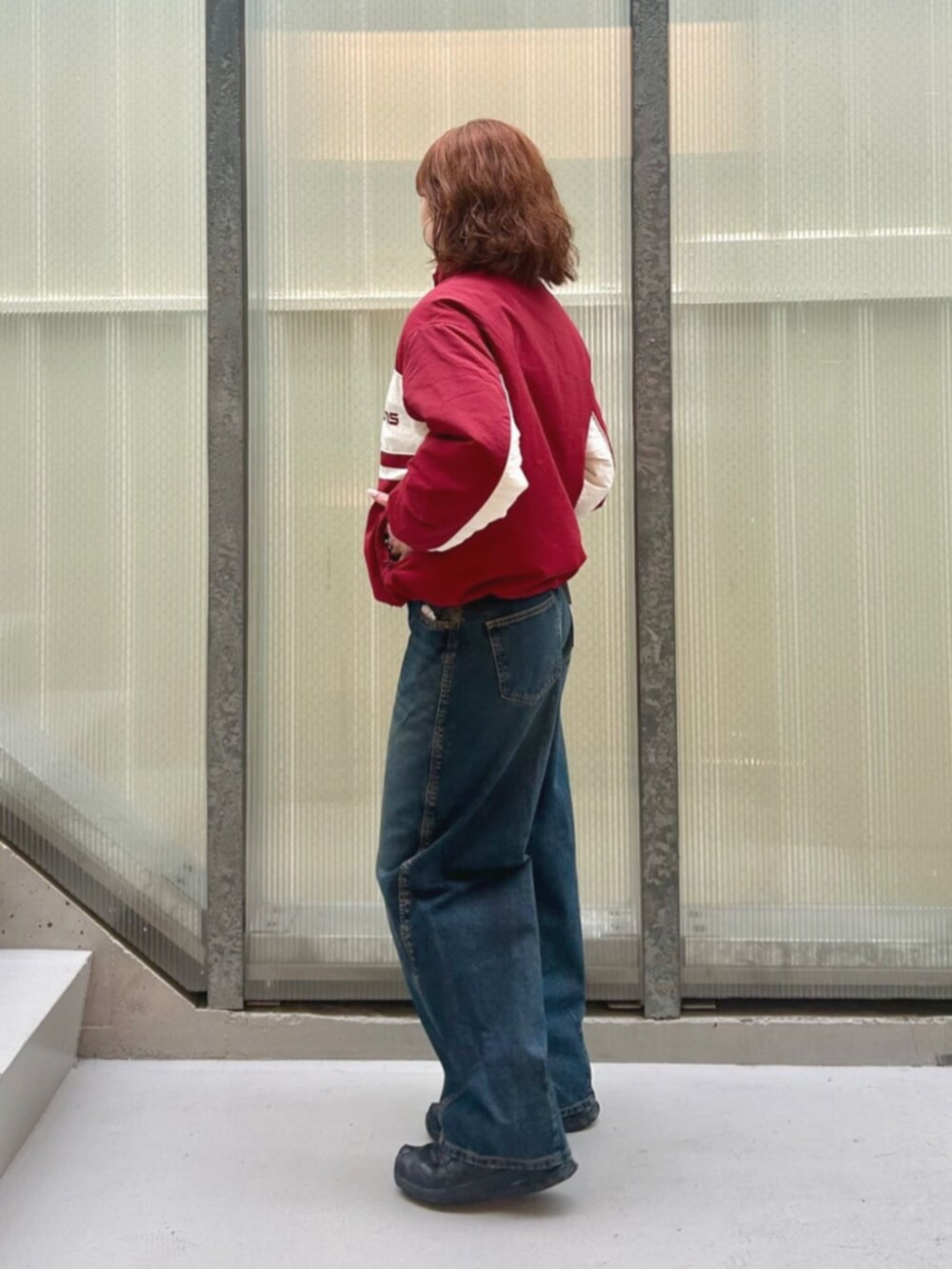 ブルー系のデニムパンツ、レッド系のナイロンジャケットを着用したレディースの冬コーディネートの3枚目の写真