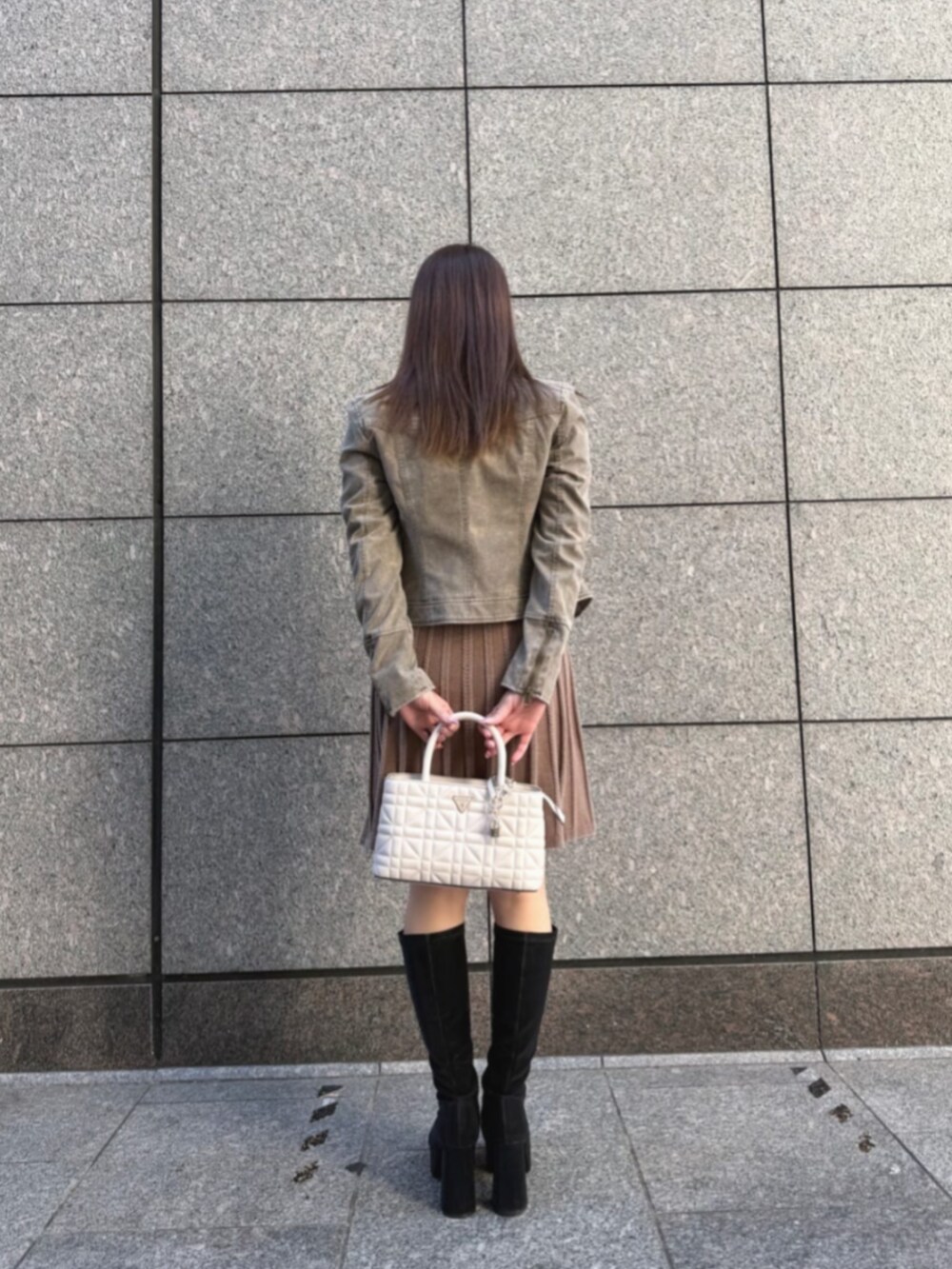 ベージュ系のノーカラージャケット、ホワイト系のショルダーバッグ、ベージュ系のワンピースを着用したレディースの秋コーディネートの2枚目の写真