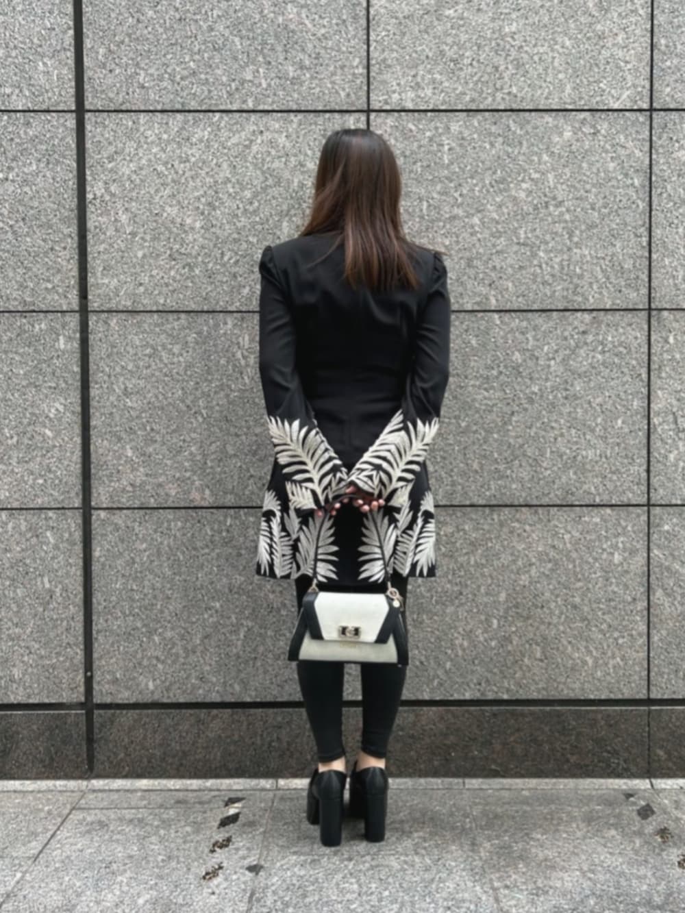 ブラック系のワンピース、ブラック系のショルダーバッグを着用したレディースの冬コーディネートの2枚目の写真