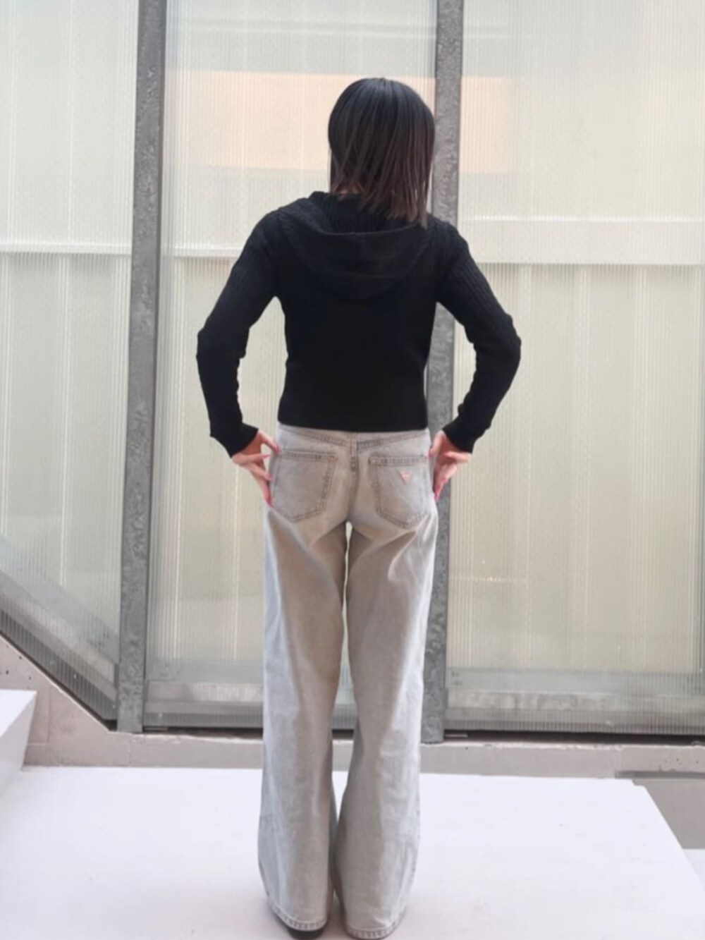 ブラック系のカーディガン/ボレロ、ブルー系のデニムパンツを着用したレディースの冬コーディネートの2枚目の写真