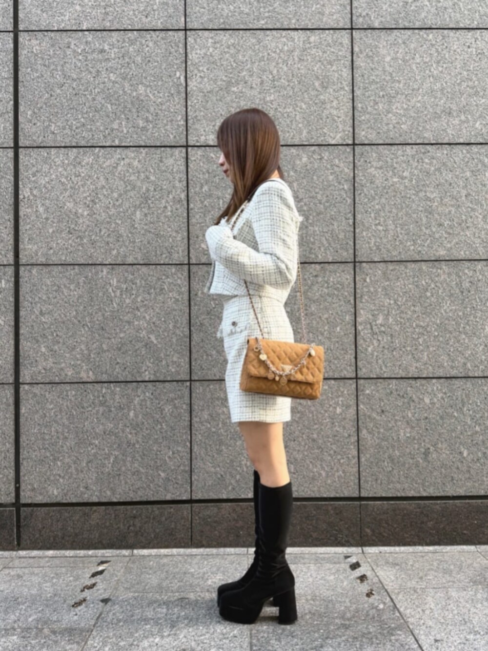 ホワイト系のその他アウター、ホワイト系のスカート、ブラウン系のショルダーバッグを着用したレディースの冬コーディネートの3枚目の写真