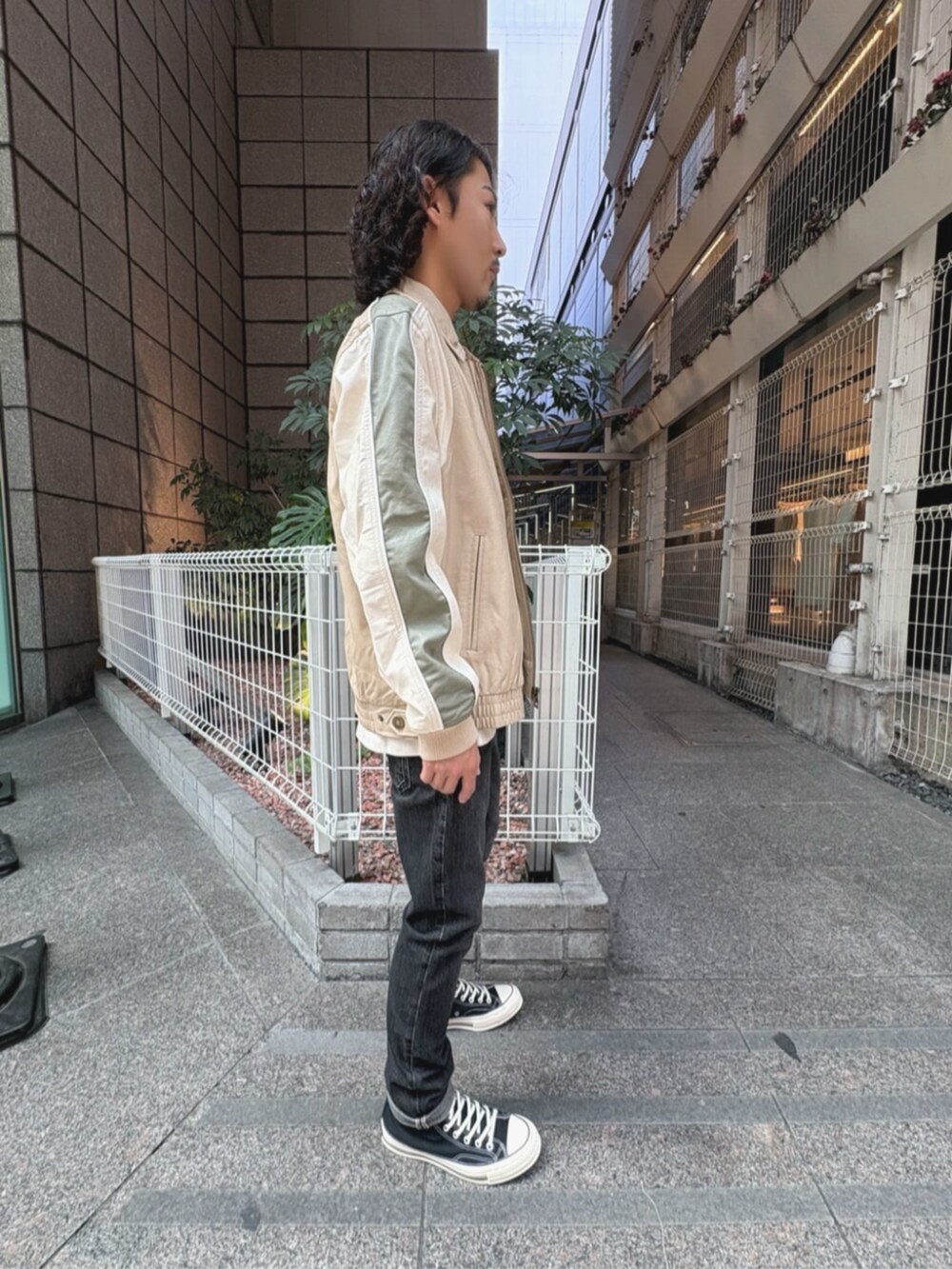 グレー系のデニムパンツ、ベージュ系のその他アウター、ホワイト系のタンクトップを着用したメンズの夏コーディネートの3枚目の写真