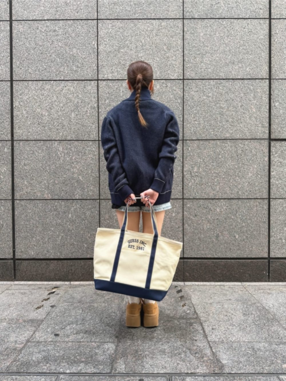 ブルー系のデニムパンツ、ブラック系のTシャツ/カットソー、ブルー系のトートバッグを着用したレディースの冬コーディネートの2枚目の写真