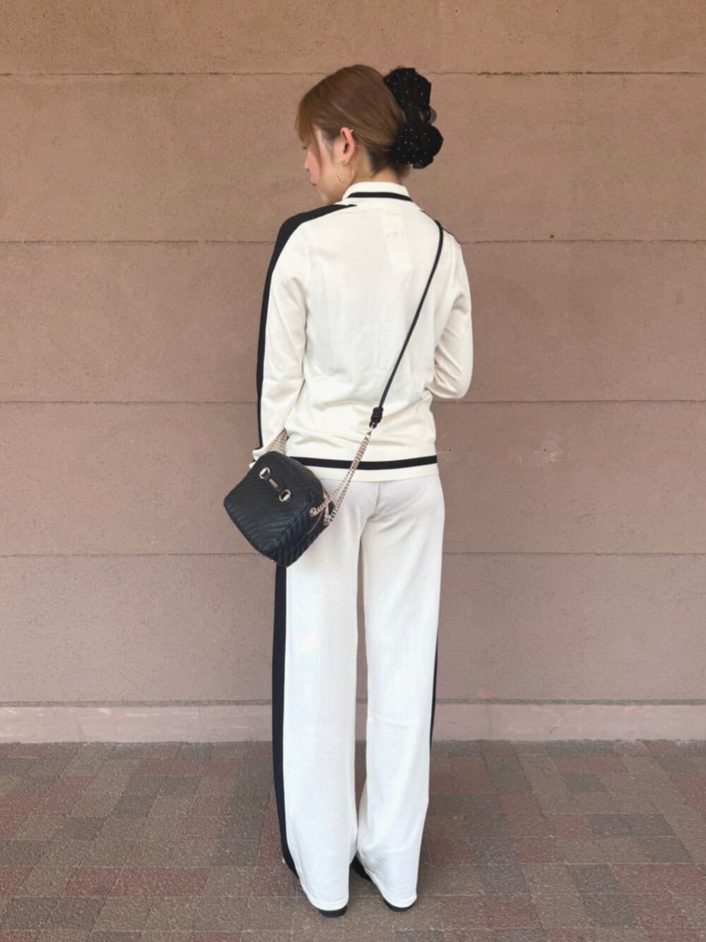 ブラック系のショルダーバッグ、ホワイト系のスウェットパンツ、ホワイト系のスウェットを着用したレディースの夏コーディネートの2枚目の写真